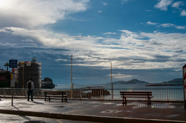 some benches and some water clouds clouds and buildings