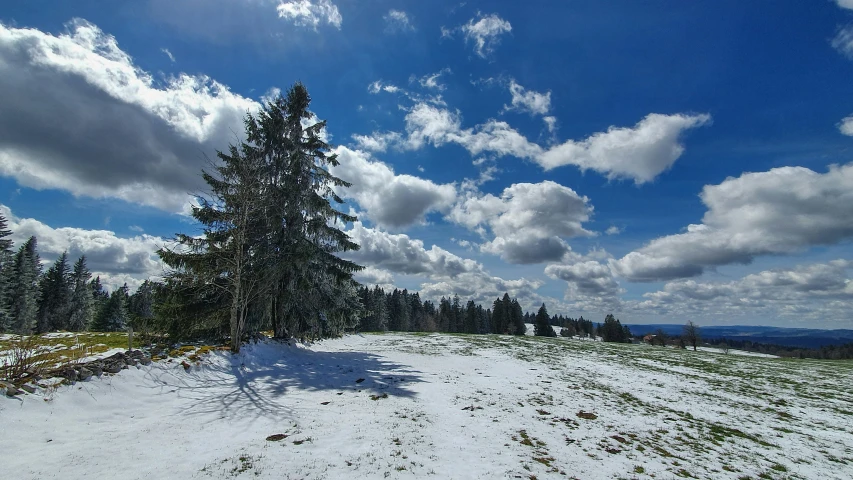 the snow covered ground beneath a partly cloudy sky