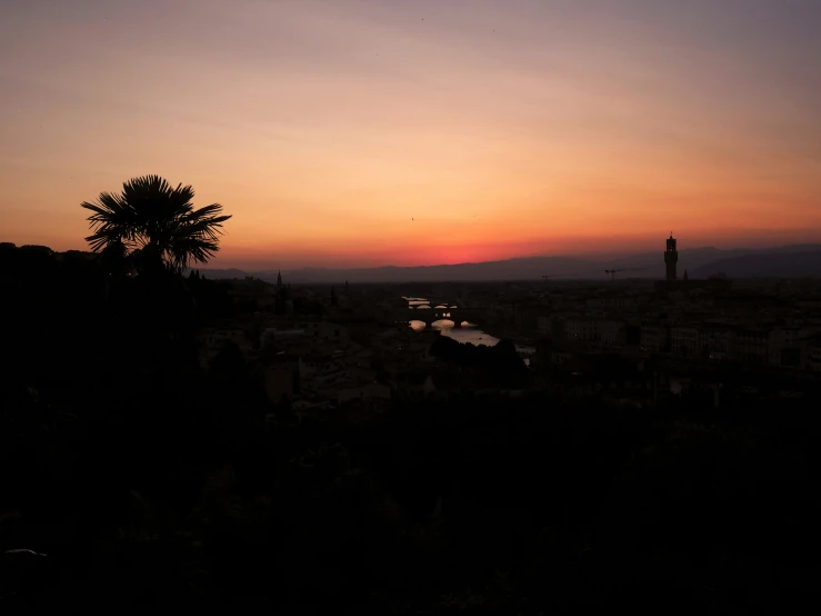 the sky has a dark sunset over a large city