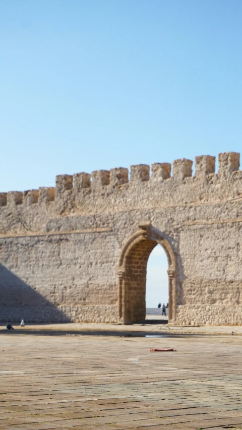 an archway leading into the outside of a stone walled wall