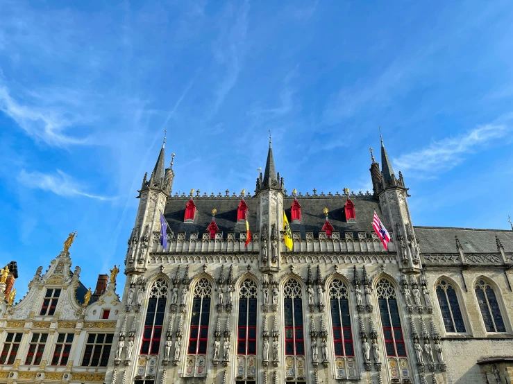 the very ornate building features many windows and flags