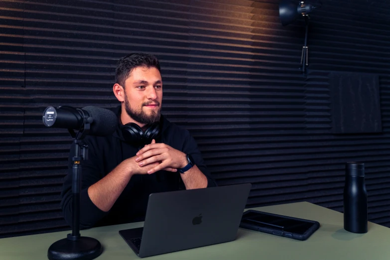 a man in headphones is using a laptop computer