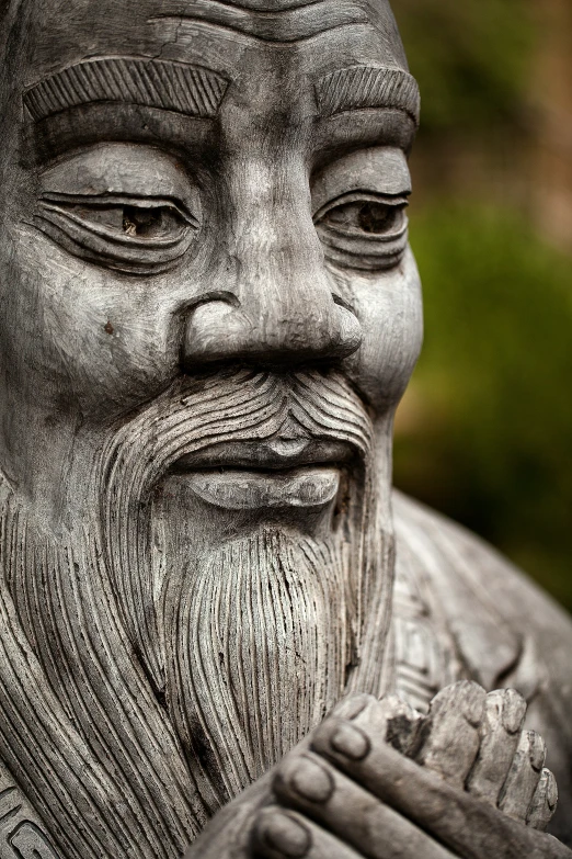 a small black statue sitting in a garden