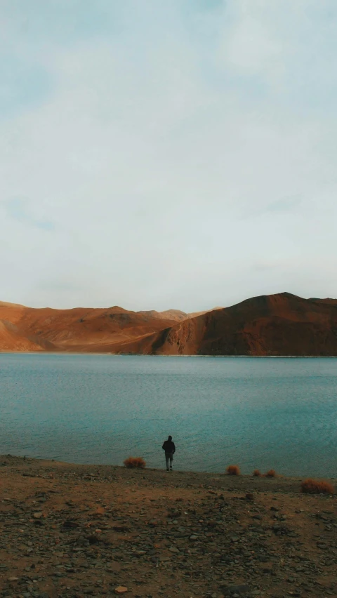 a large body of water with a person walking on it