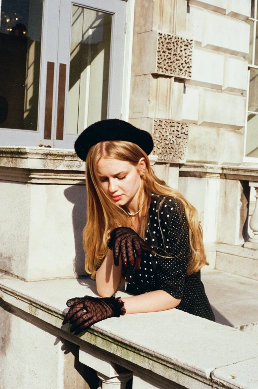 a lady sitting down with gloves on and posing for the camera