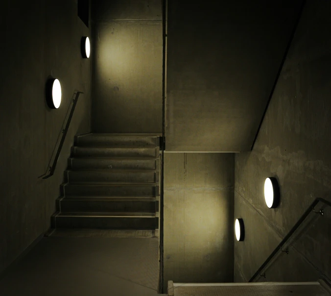 a dark room with some stairs and circular windows