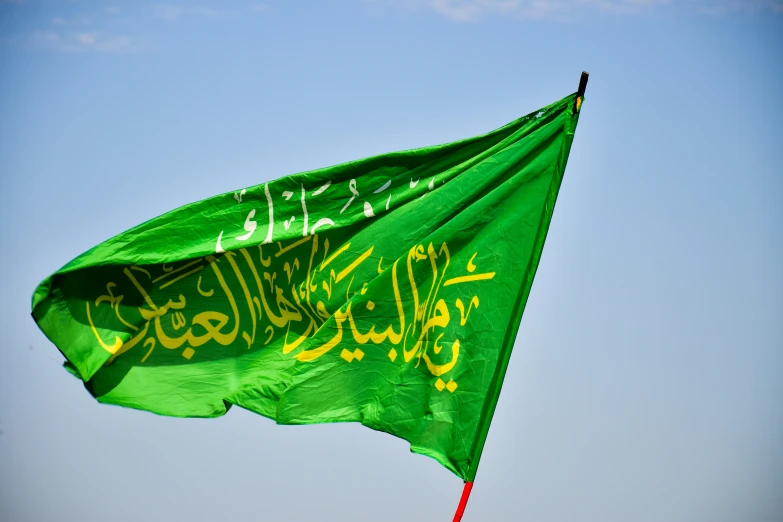 an open green islamic kite in the air