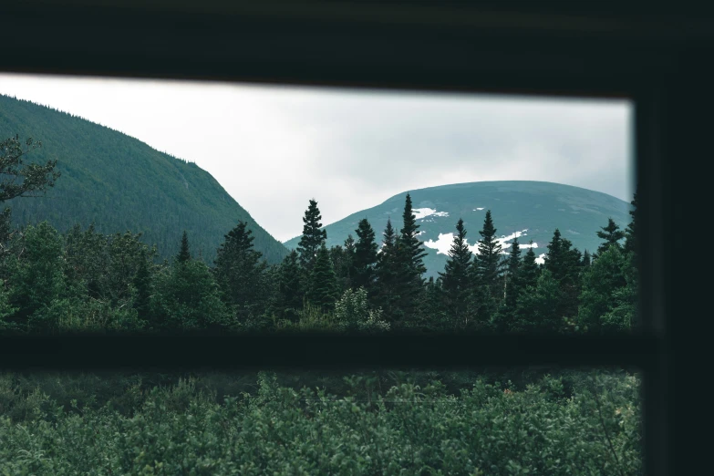 view of a snowy mountain from inside of a window