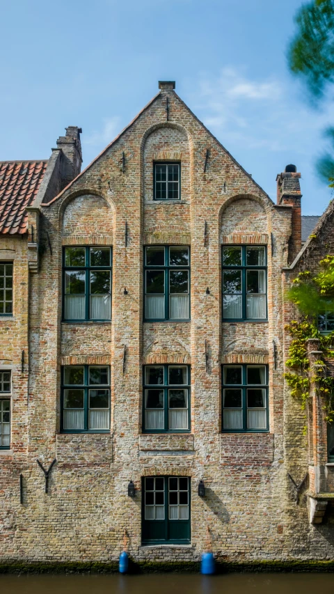 a brick building sitting next to water and other buildings