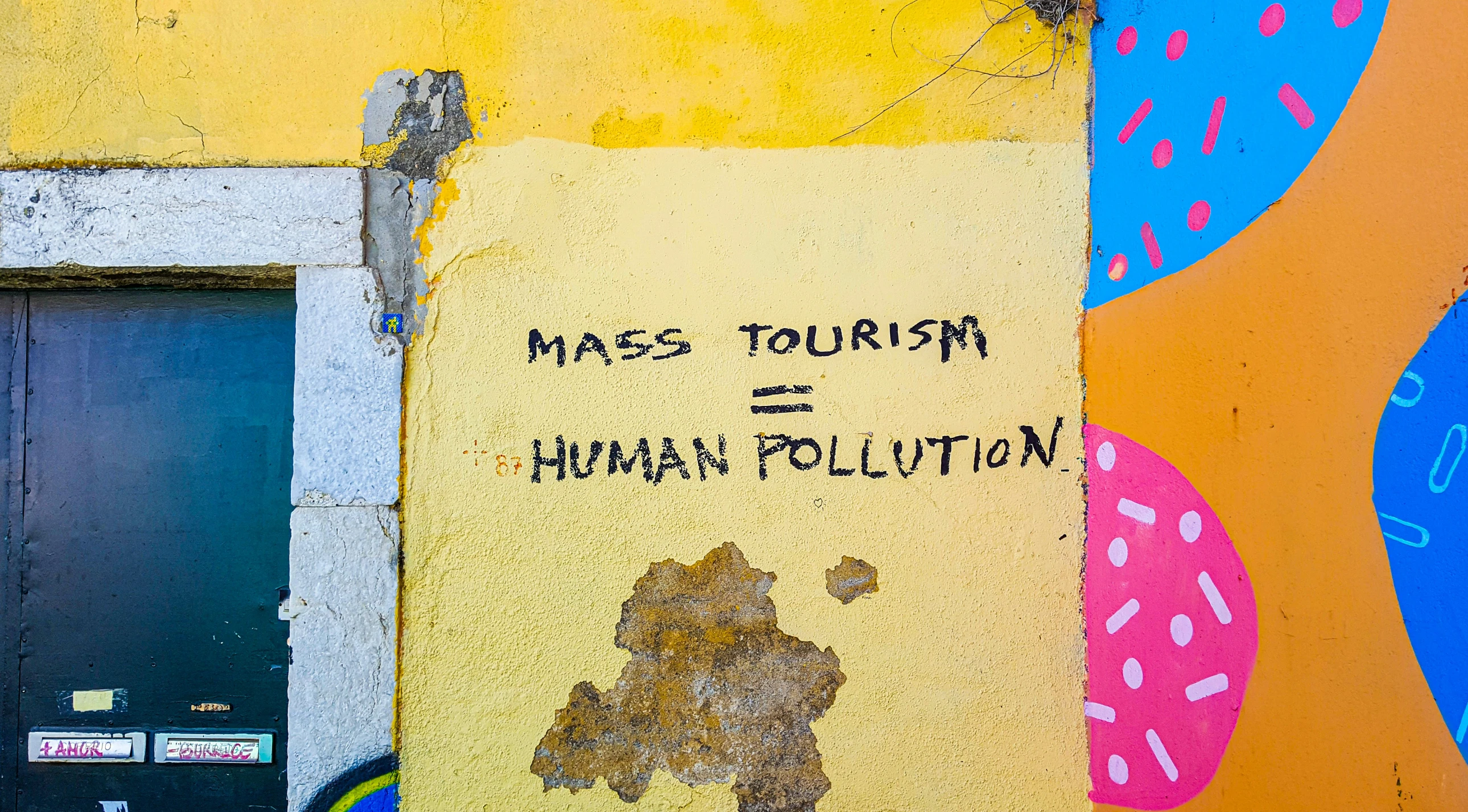 a sign on the side of a building that reads mass touriste human pollution