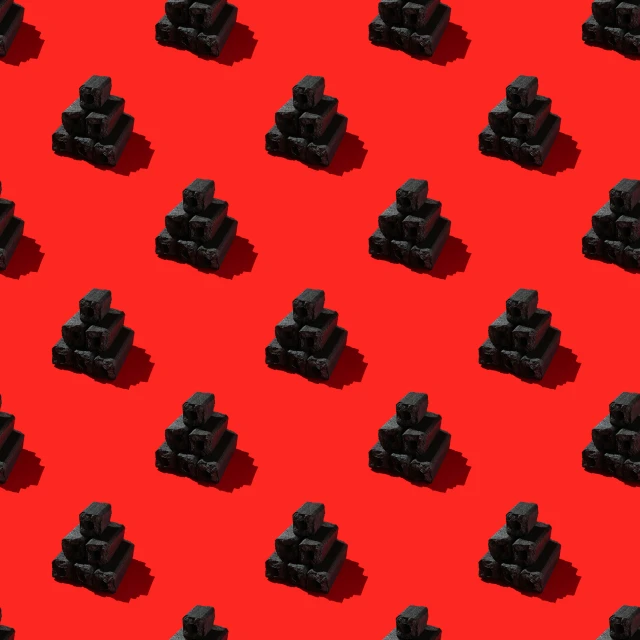 a group of black legos sitting together on a red surface
