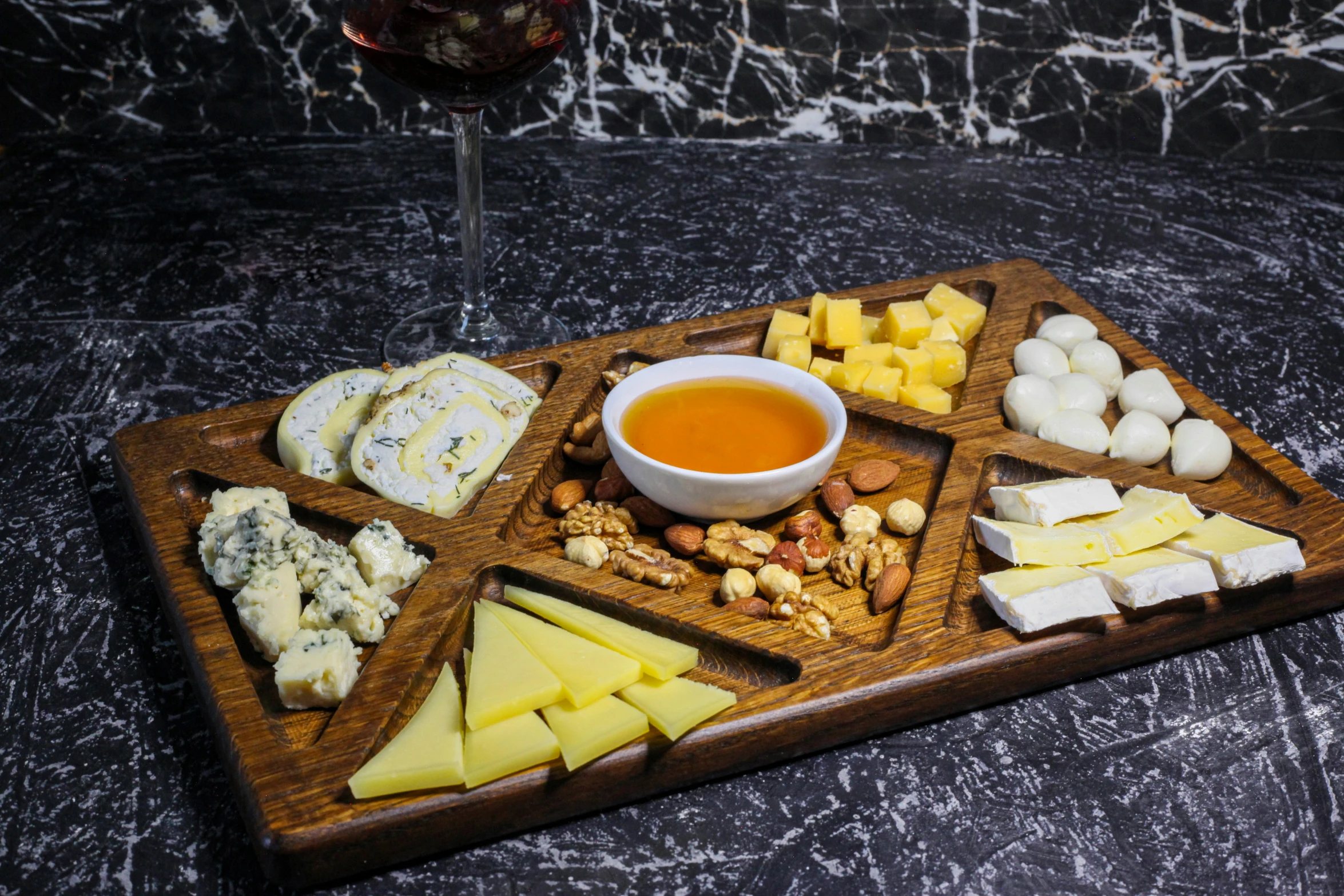 a plate with cheeses, nuts and juice