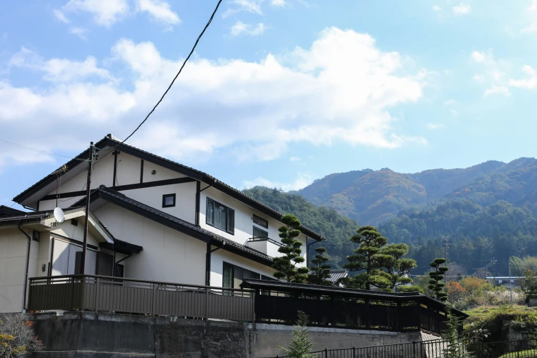 an house in front of some mountain and a sky