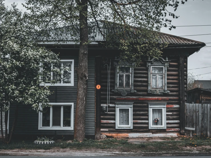 a wood - paneled house on the corner of an urban street