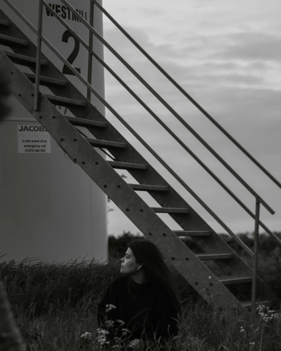 a woman sitting next to stairs next to a tall building