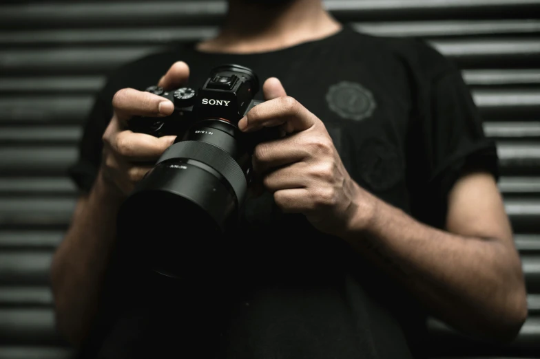 man holding and looking at camera in hand with other hands