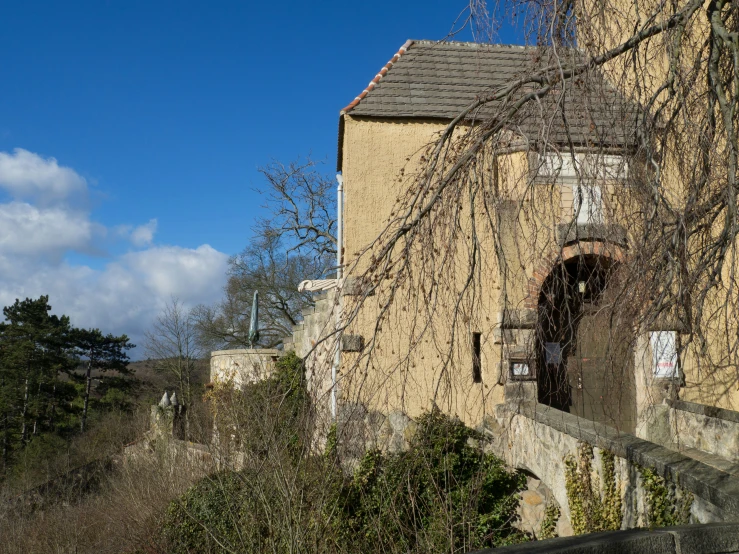 a large yellow house with a window and a tree