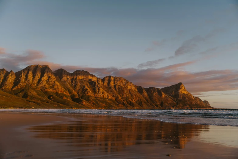 mountain side view of rocky ocean shore during sunset