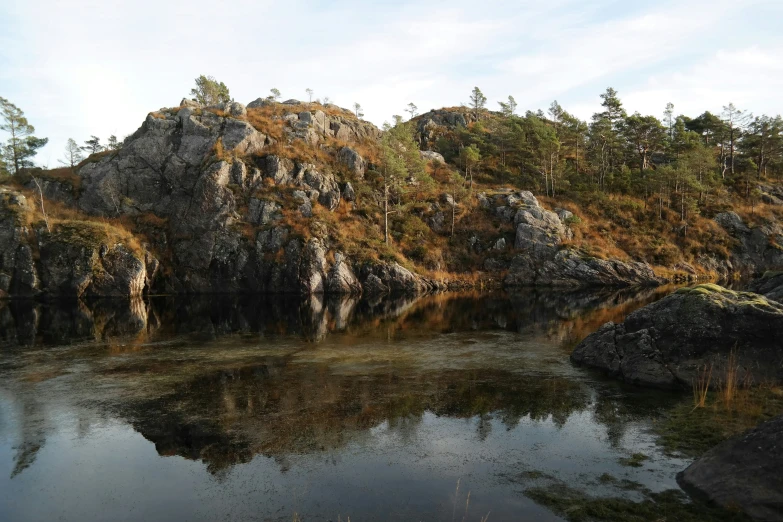 a small lake sits on the edge of a hill