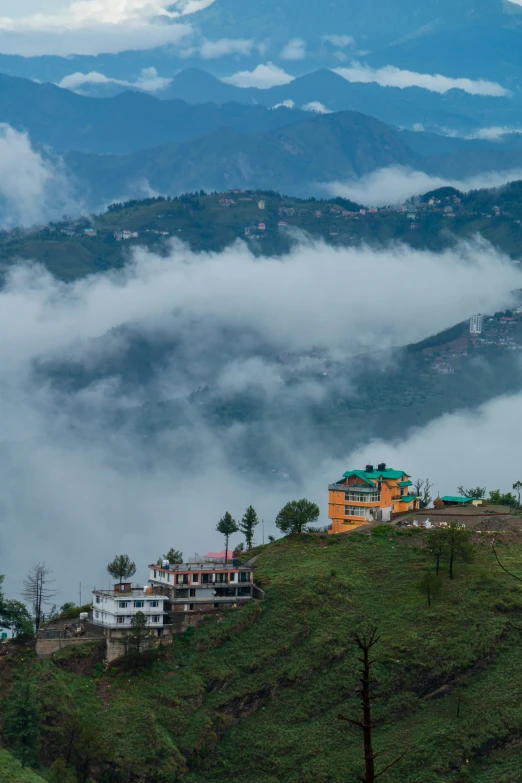 a house sitting on top of a hill under a cloudy sky