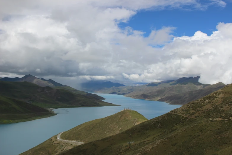 a mountain overlooking a river with mountains in the background