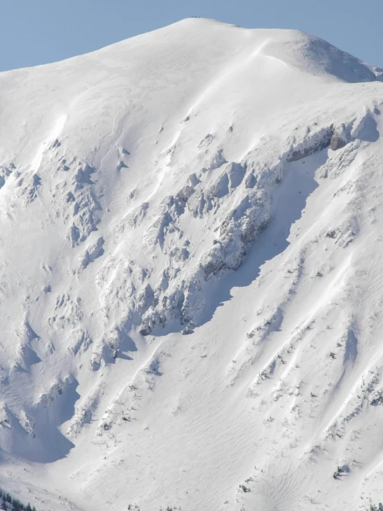 a mountain side with a skier coming down it