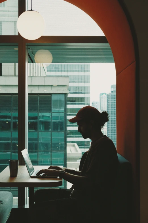 a woman is sitting at a table working on her computer