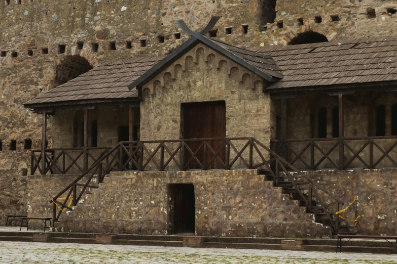 an old building has stairs leading to the front and side