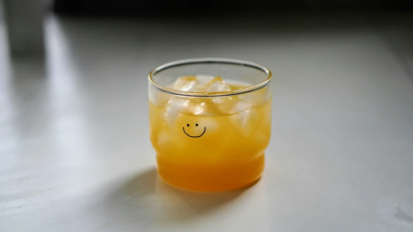 a glass of juice with a smiley face drawn on it