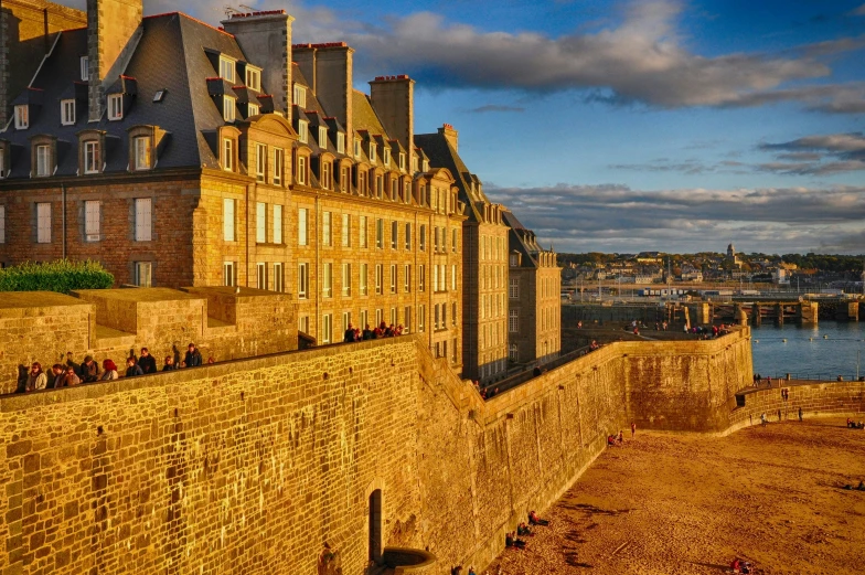 a castle and other buildings are lit by the sunlight