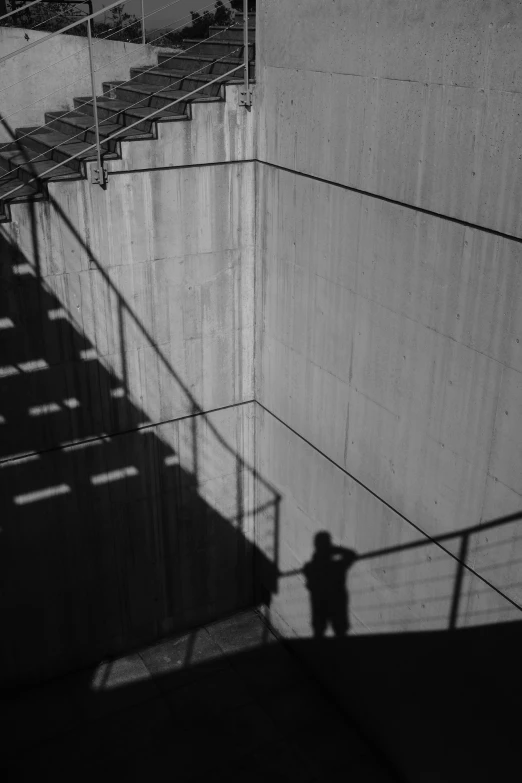 a lone person is in front of a cement wall