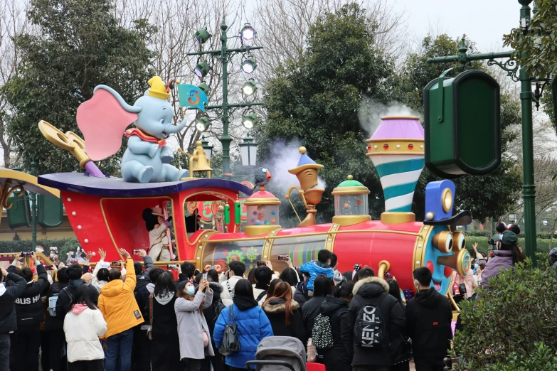 people standing in a crowd around an elaborate float at an amut park