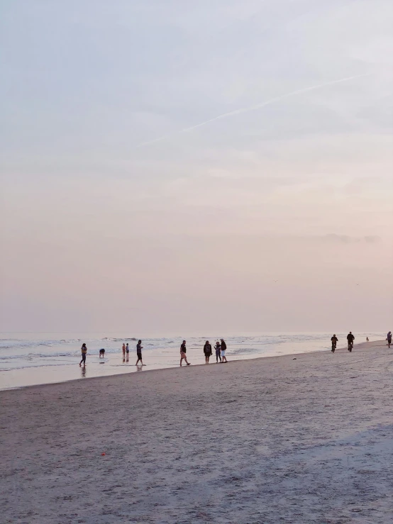 a bunch of people walking down the beach near the ocean