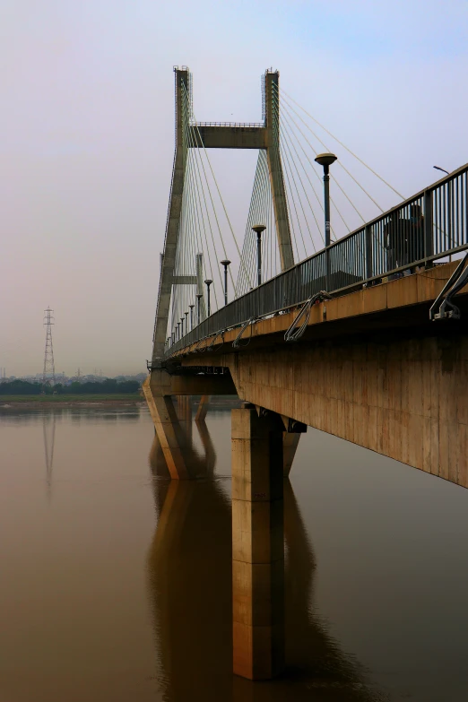 a bridge is spanning over the water with a tall structure