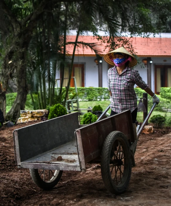 a woman hing a wheelbarrow with an open wagon