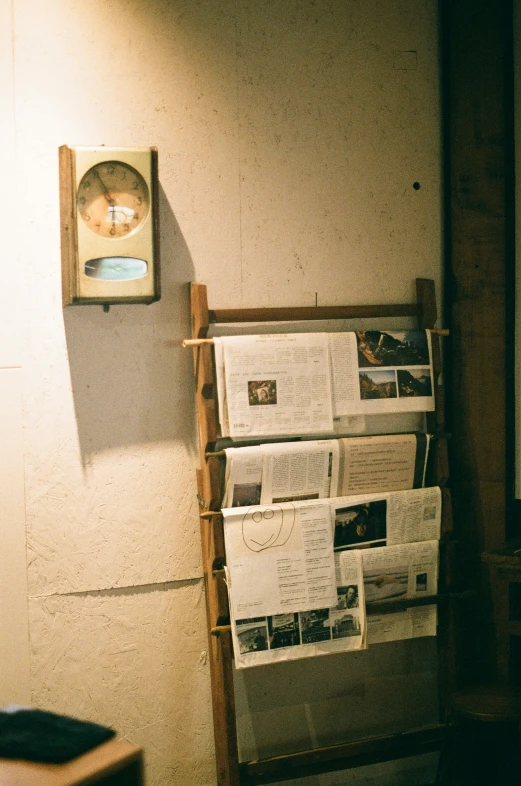 newspapers are piled on top of the shelf in the corner