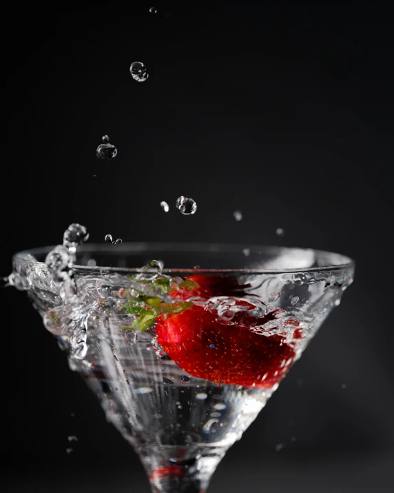 a strawberry and a drink in a martini glass