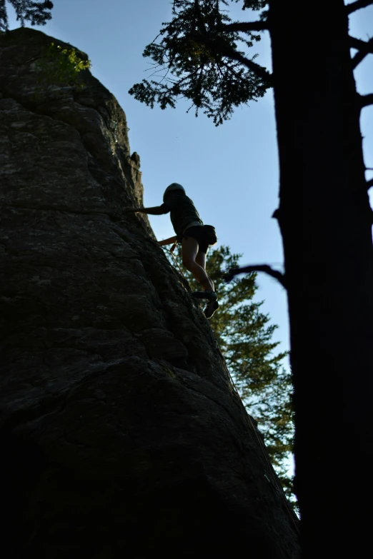 a person climbing up the side of a large rock