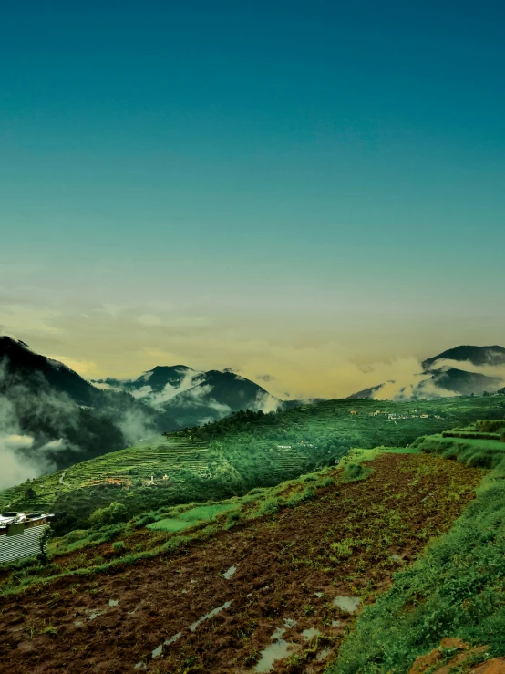 the mountains are covered in clouds and grass