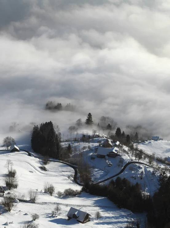 snow covered mountains with houses on a hill below