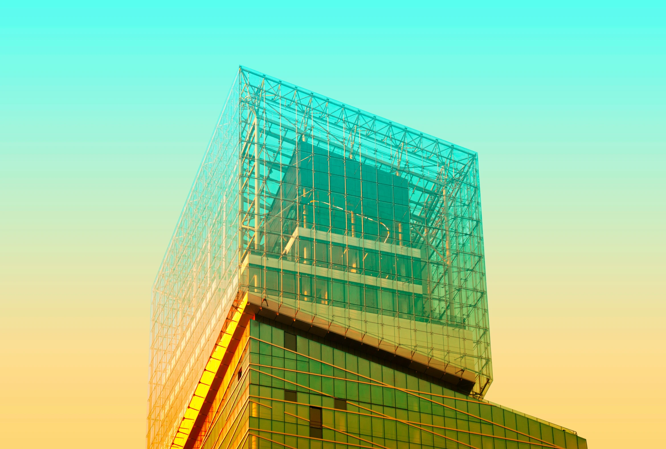 the top half of a glass building, against an orange sky