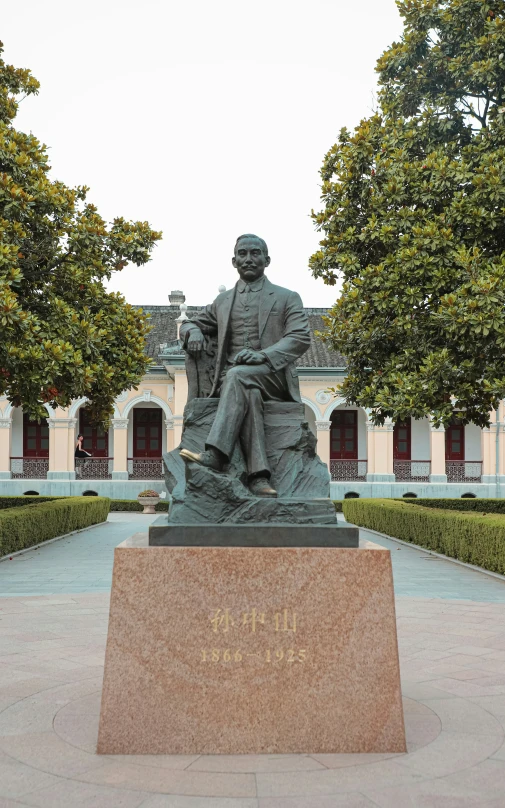 a bronze statue is sitting at the base of a bench