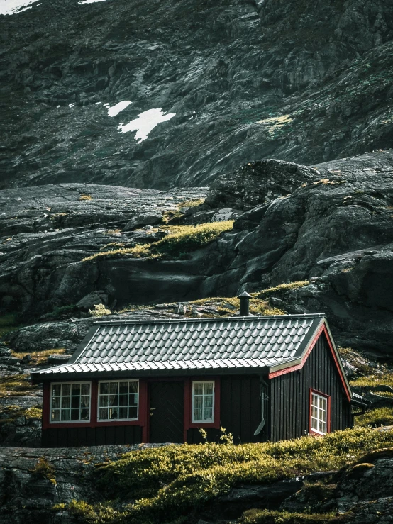 a small hut with mountains in the background