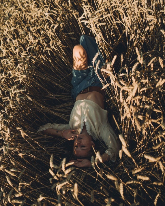 a person lying down in the middle of dry grass