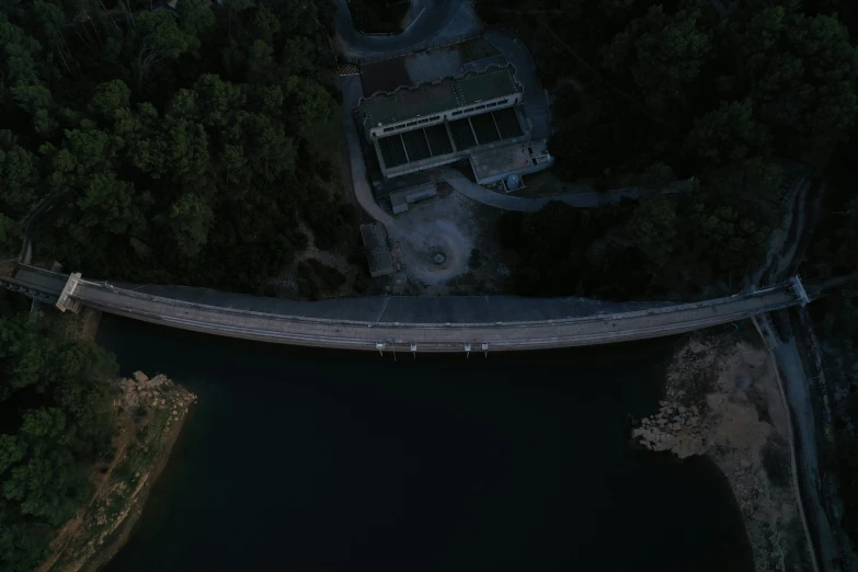 an aerial view of the top part of a bridge over water at night