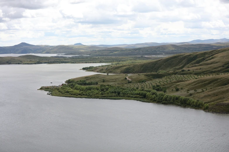 an aerial s of water and land with mountains in the background