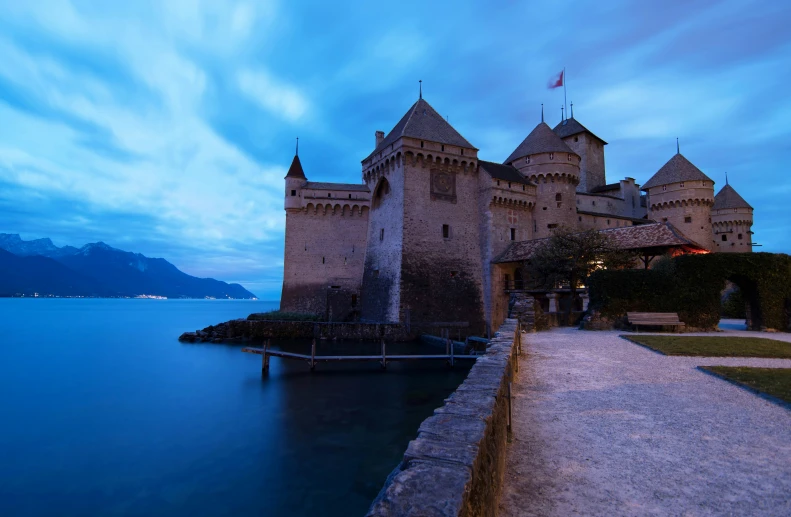 the ocean and a castle by the shore at night