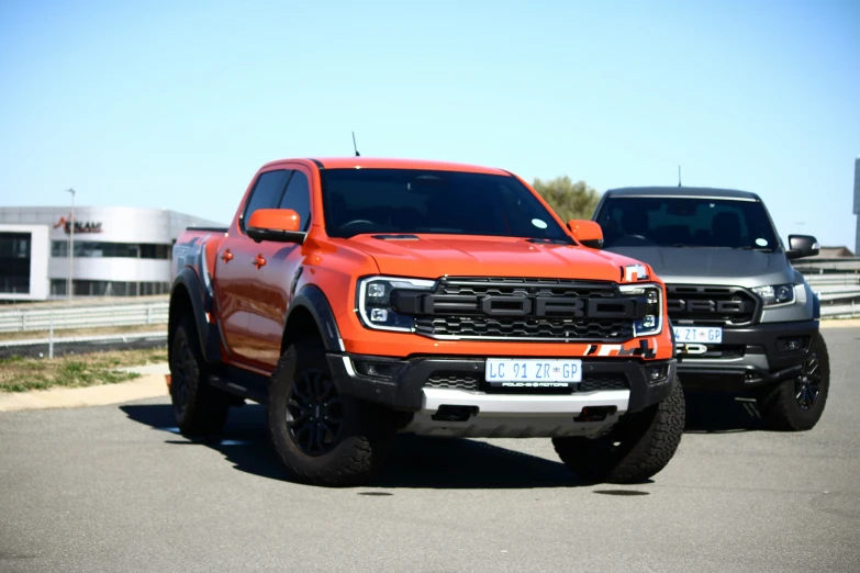 two red trucks are parked side by side