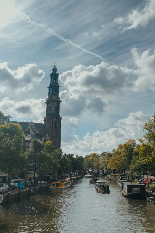 a clock tower towering over the water in a city