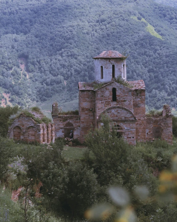 the building is in the middle of the hill with some trees